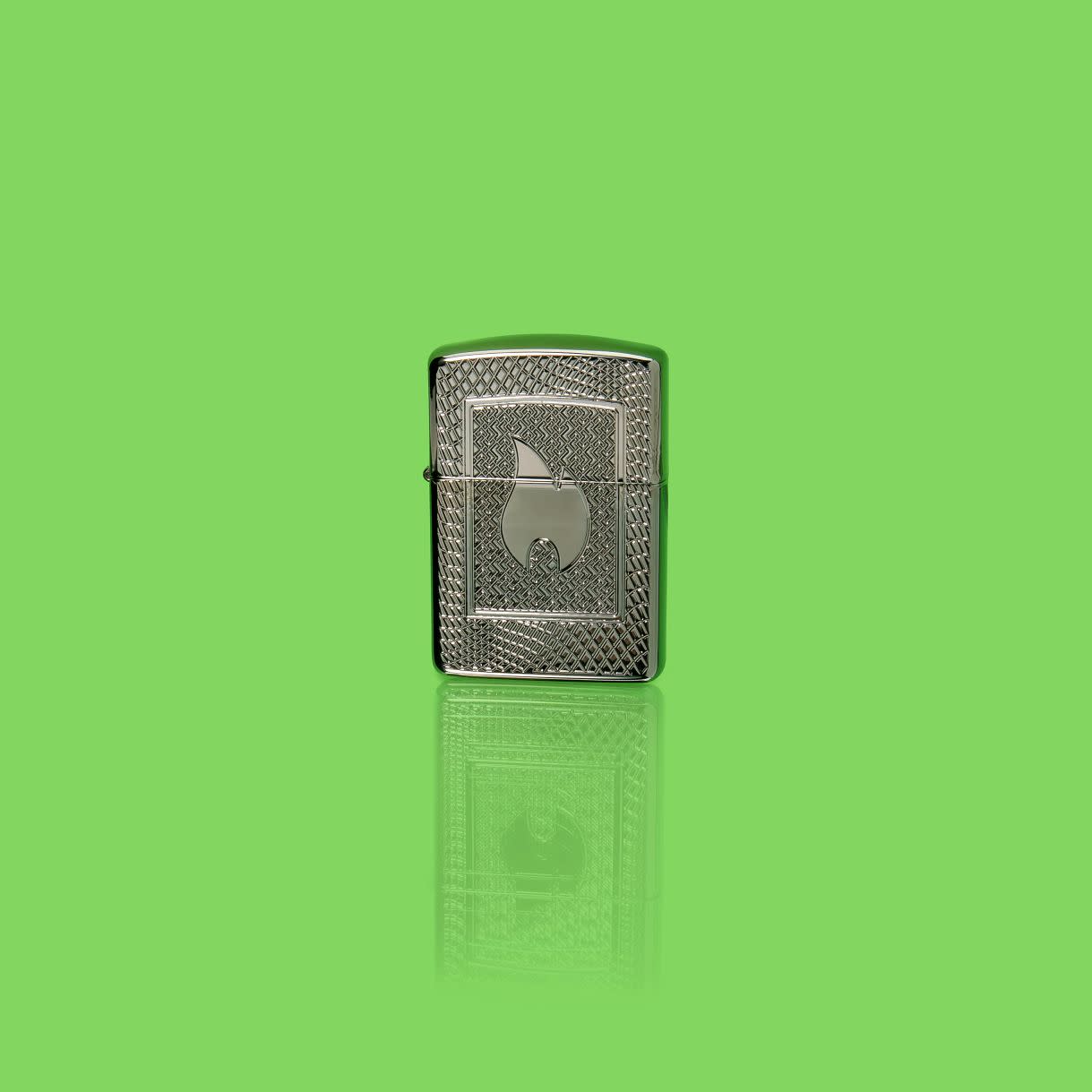 Glamour shot of Zippo Flame Pattern Design Armor Black Ice Windproof Lighter standing in a green scene.