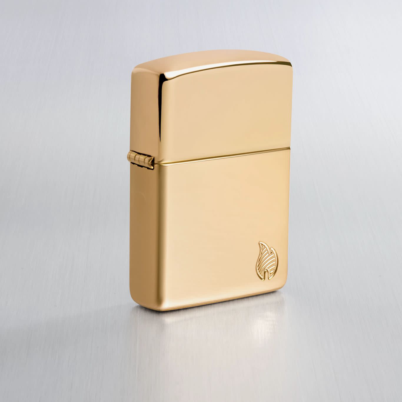 Lifestyle image of Zippo Armor?? Series Flame High Polish Brass Windproof Lighter on a light gray background.