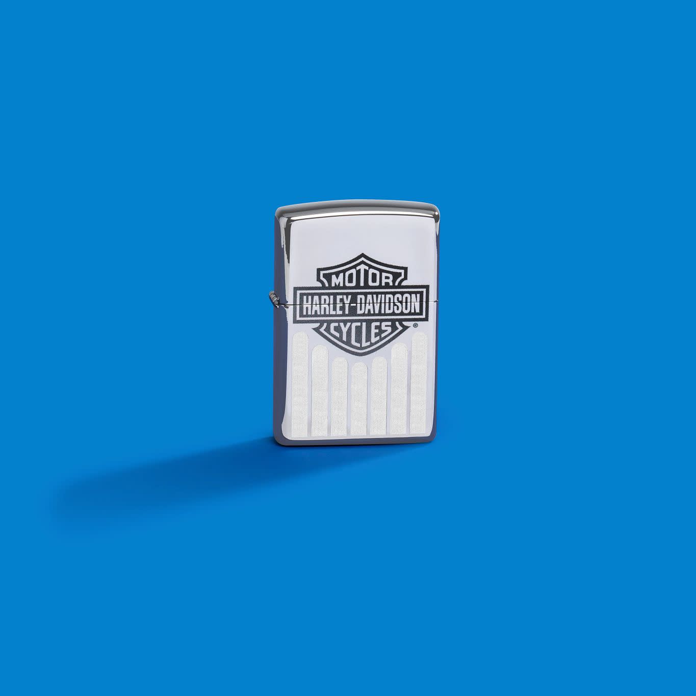 Lifestyle image of Zippo Harley-Davidson?? High Polish Chrome Windproof Lighter on a blue background.