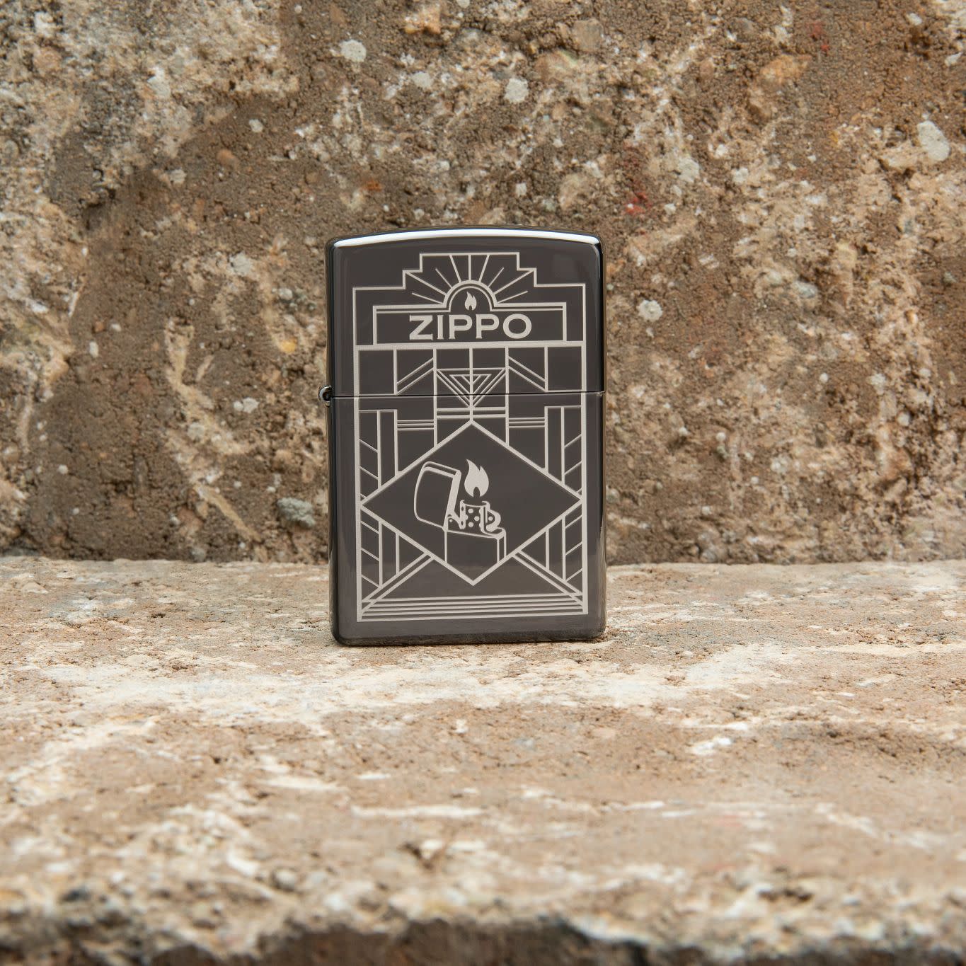 Lifestyle image of Zippo Art Deco Design Black Ice?? Windproof Lighter standing on a counter top.