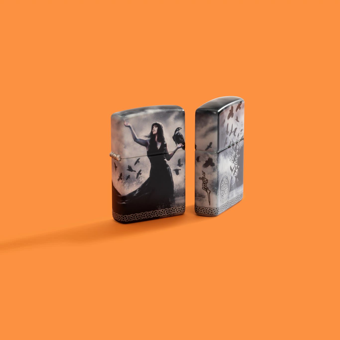 Lifestyle image of two Zippo Mazzi?? 540 Matte Windproof Lighters on an orange background.