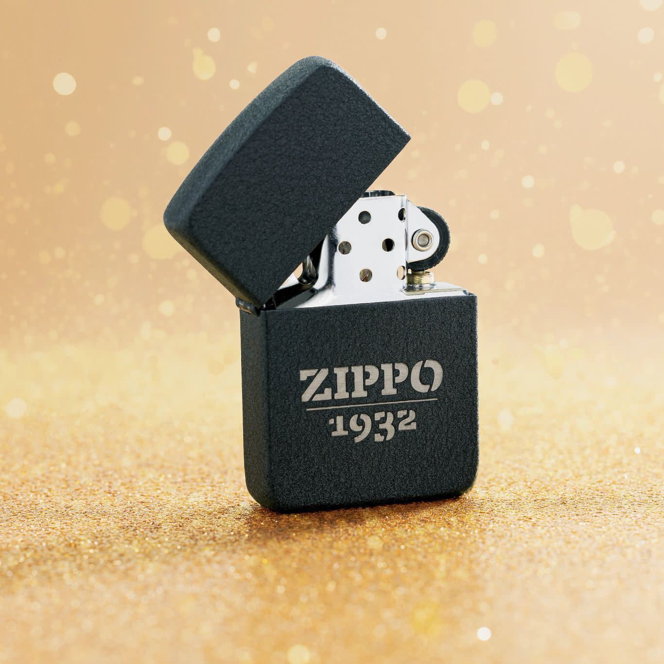 Lifestyle image of Zippo Design 1941 Replica Black Crackle?? Windproof Lighter standing on a golden surface with glittery flakes surrounding it.